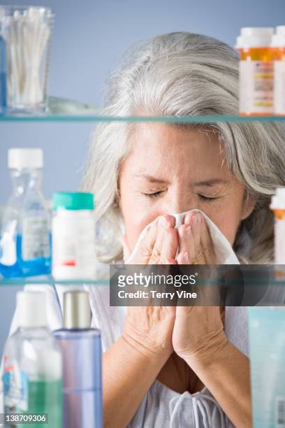 hispanic woman sneezing in bathroom - closeup of a hispanic woman sneezing foto e immagini stock