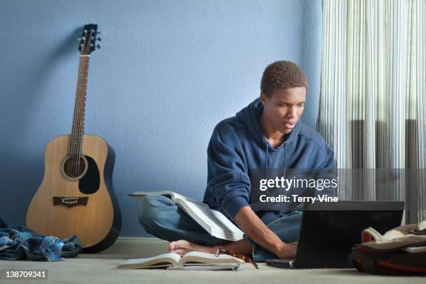 mixed race teenager doing homework with laptop - teen boy barefoot stock pictures, royalty-free photos & images