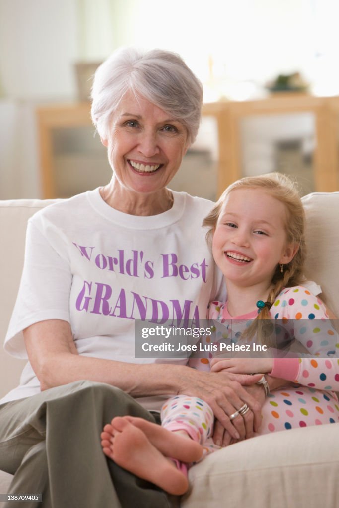 Caucasian grandmother and granddaughter sitting on sofa together