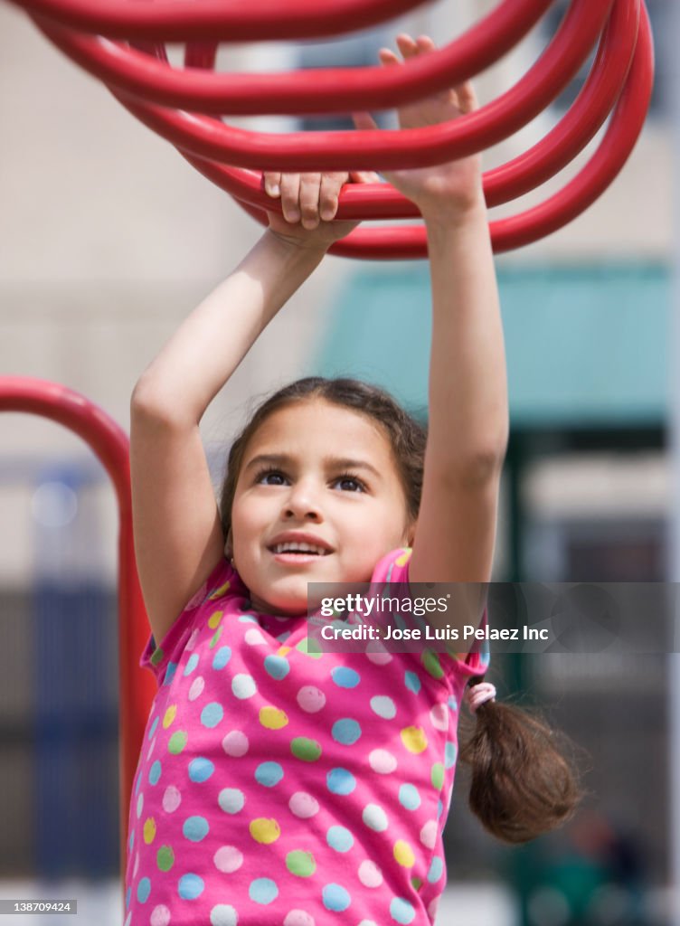 Hispanic girl playing on playground structure