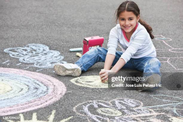 hispanic girl drawing on ground with chalk - sidewalk chalk drawing stock pictures, royalty-free photos & images