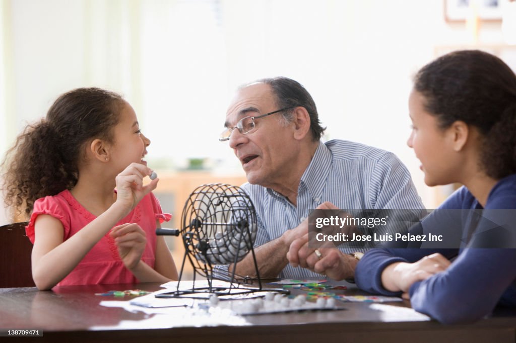 Hispanic girls and grandfather playing game