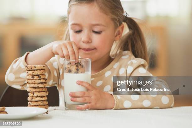 caucasian girl dunking cookies in milk - dipping fotografías e imágenes de stock