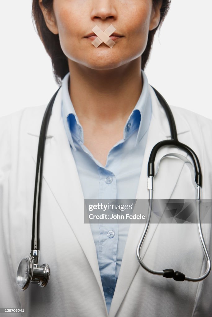 Hispanic doctor with bandages on mouth