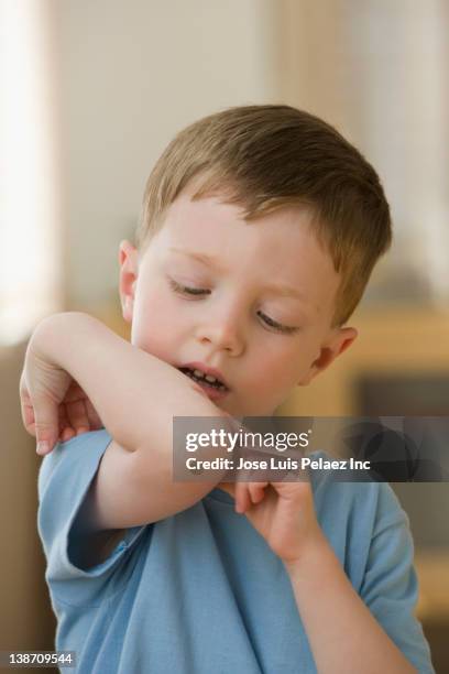 caucasian boy looking at wound on elbow - touching elbows stock pictures, royalty-free photos & images