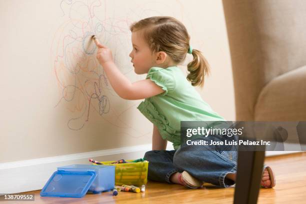 caucasian girl drawing on wall - kid holding crayons stockfoto's en -beelden