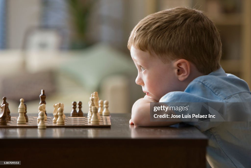 Caucasian boy playing chess