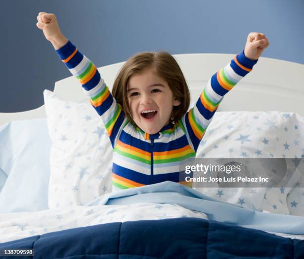 mixed race boy waking up in bed - kids pajamas stock pictures, royalty-free photos & images