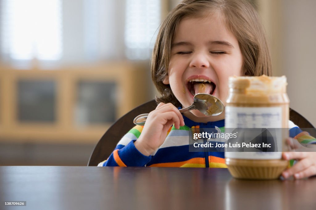 Mixed race boy eating peanut butter