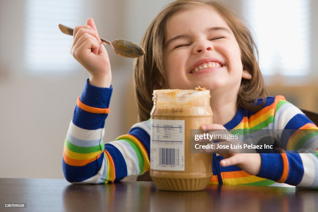 Mixed race boy eating peanut butter