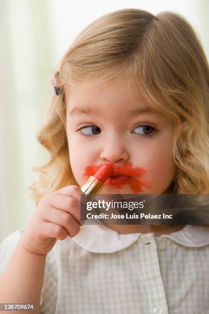 caucasian girl putting on lipstick - kids makeup stock pictures, royalty-free photos & images