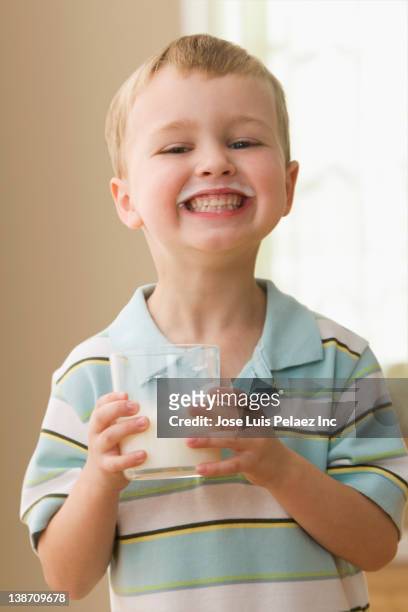 grinning caucasian boy drinking milk - boy drinking milk stock pictures, royalty-free photos & images