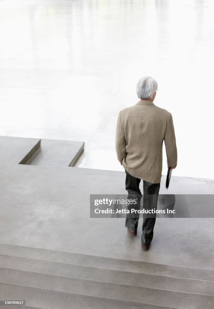 Asian businessman walking down steps