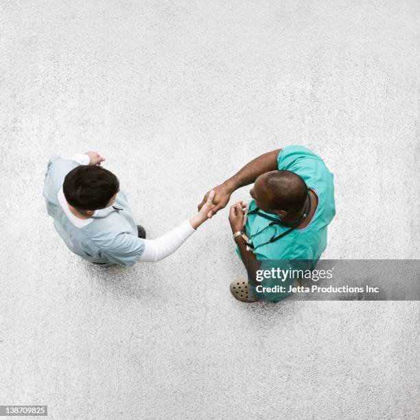 doctors shaking hands in lobby - healthcare and medicine from above stock pictures, royalty-free photos & images