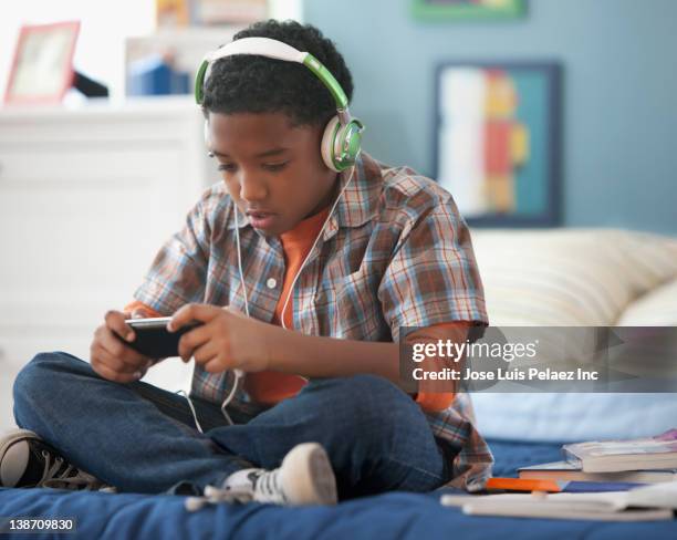 mixed race boy listening to mp3 player - boy ipod stock pictures, royalty-free photos & images