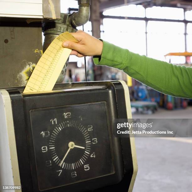 hispanic worker clocking in in factory - time card stock pictures, royalty-free photos & images