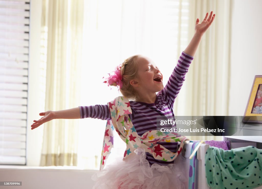 Caucasian girl singing with arms outstretched