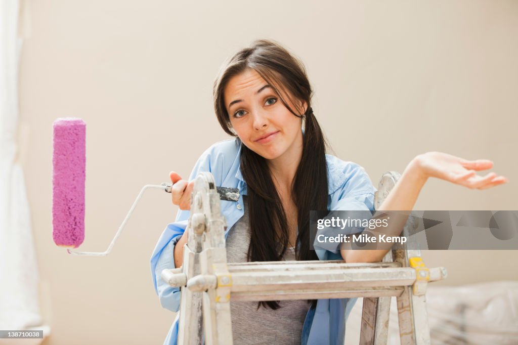 Caucasian woman holding paint roller