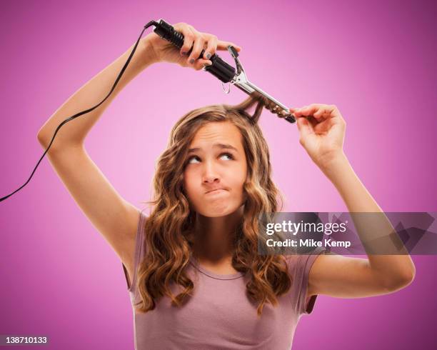 caucasian teenager curling her hair - hair curlers stock pictures, royalty-free photos & images