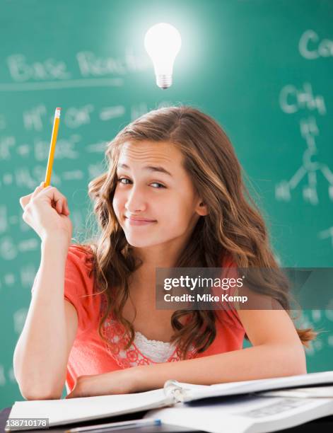 caucasian student with light bulb over her head - 13 pencils stock-fotos und bilder