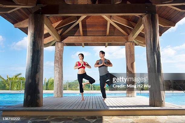 couple practicing yoga together - asian man barefoot foto e immagini stock