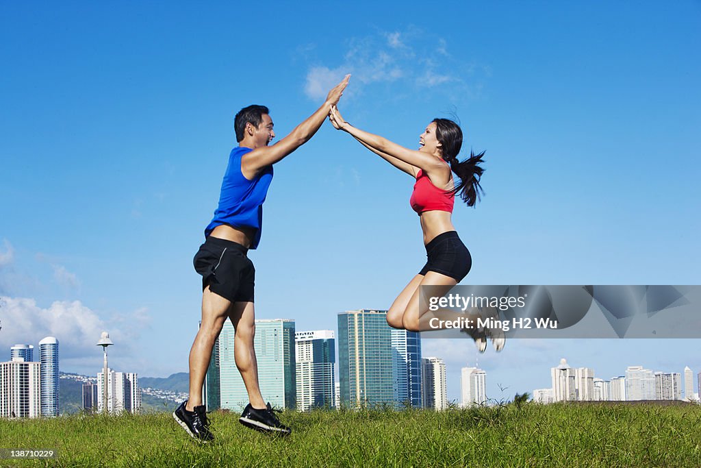 Couple high-fiving in field