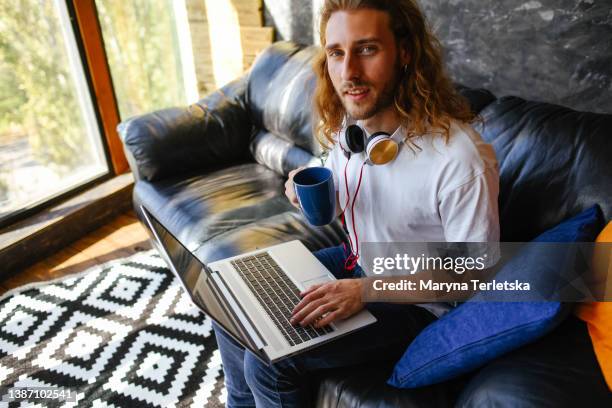 the young guy works at the laptop. home pastime. remote work. distance learning. - copy writing stock pictures, royalty-free photos & images