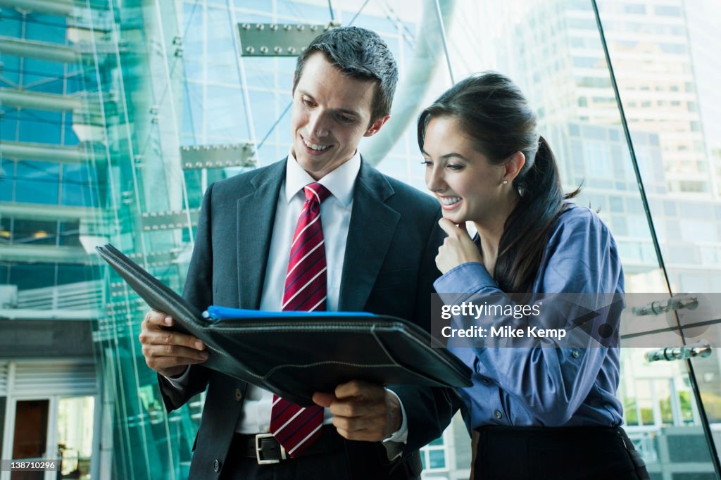 Caucasian business people looking at notebook together