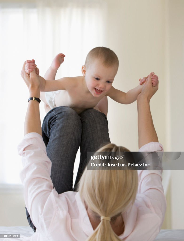 Caucasian mother playing with baby daughter