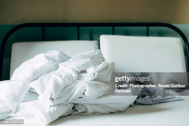 duvet, and pillows on a bed without cover in a bedroom - beddengoed stockfoto's en -beelden