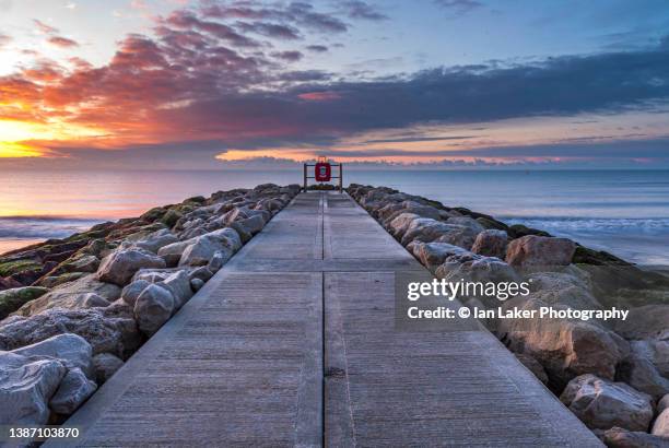 branksome, dorset, england, uk. 20 february 2010. branksome chine beach at dawn - golden hour beach stock pictures, royalty-free photos & images