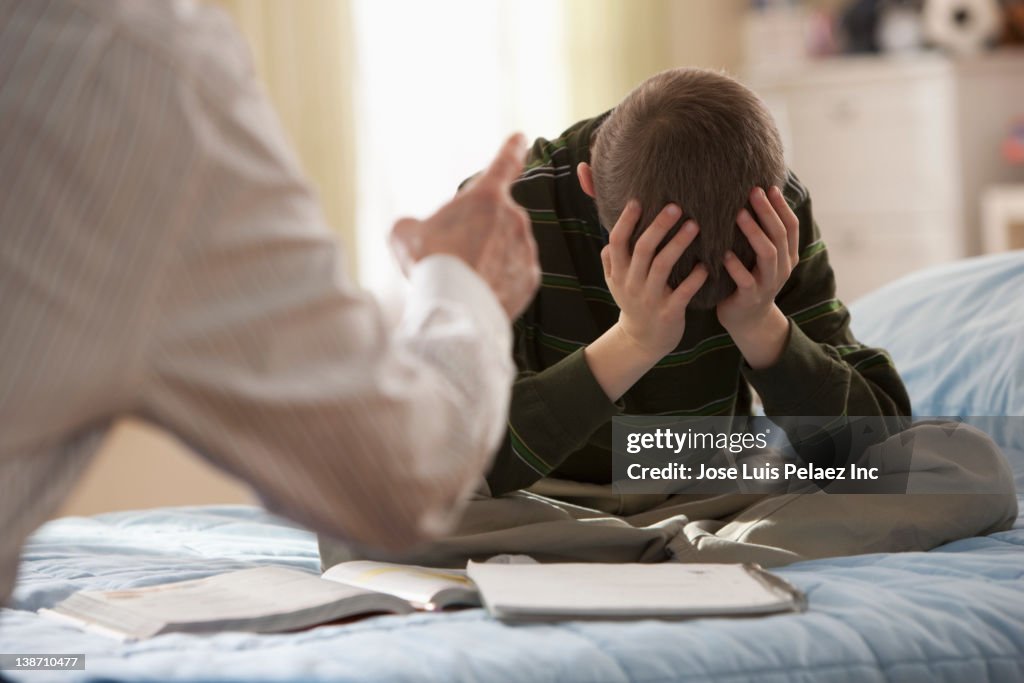 Father lecturing son in bedroom