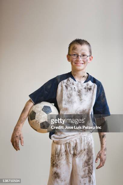 dirty caucasian boy holding soccer ball - strip stock-fotos und bilder