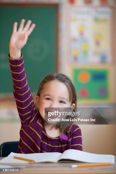 caucasian girl raising hand in classroom - children raising their hands stock pictures, royalty-free photos & images