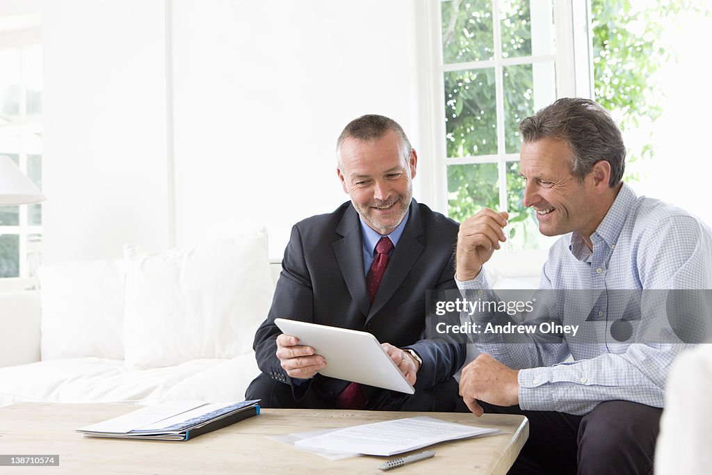 Financial advisor showing digital tablet to customer