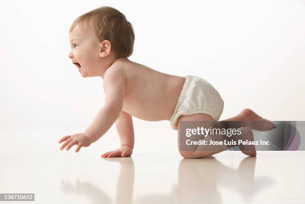 mixed race baby boy crawling - crawling stock pictures, royalty-free photos & images