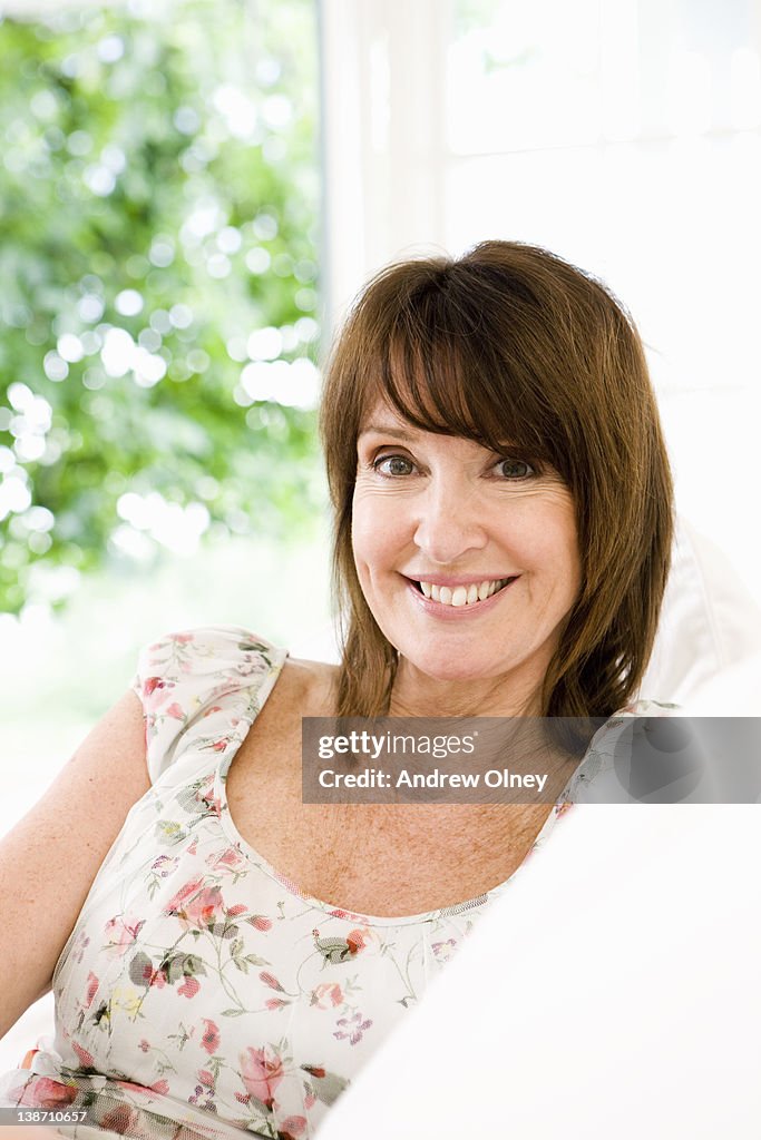 Smiling woman sitting on sofa