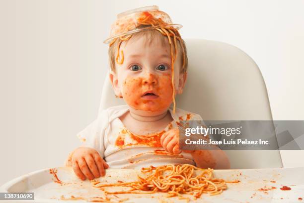 mixed race baby boy eating spaghetti - 男の赤ちゃん一人 ストックフォトと画像