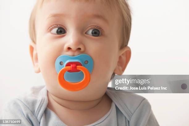 mixed race baby boy sucking pacifier - pacifier stockfoto's en -beelden