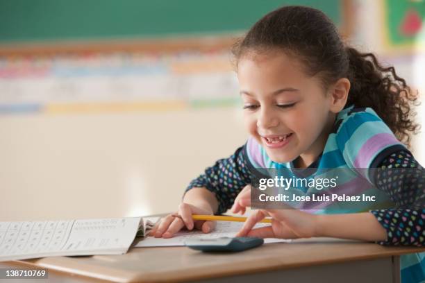 hispanic girl studying in classroom - adding calculator stock pictures, royalty-free photos & images