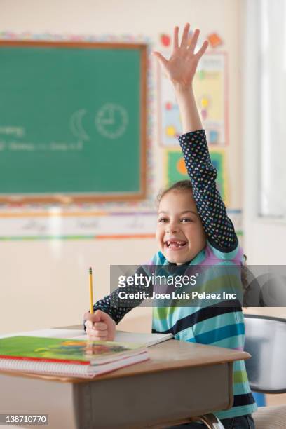 hispanic girl raising hand in classroom - teachers pet stock pictures, royalty-free photos & images