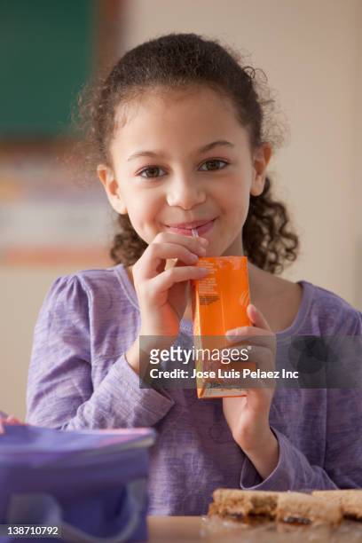 hispanic girl drinking juice box for lunch at school - physical stance stock pictures, royalty-free photos & images