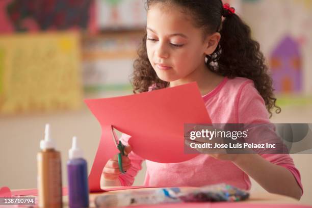 hispanic girl cutting paper in classroom - construction paper stock pictures, royalty-free photos & images
