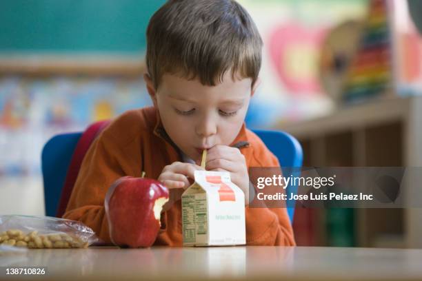 caucasian boy eating lunch in classroom - school lunch bildbanksfoton och bilder