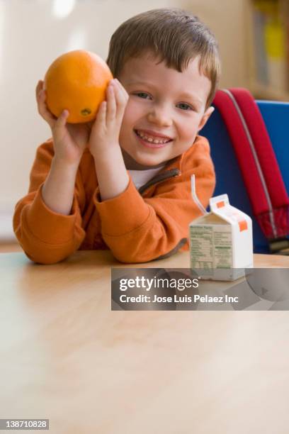 caucasian boy eating snack in classroom - juice box stock pictures, royalty-free photos & images