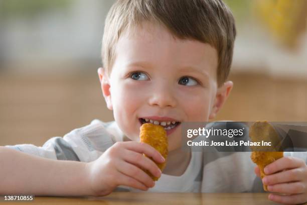 caucasian boy eating chicken nuggets - chicken nugget photos et images de collection