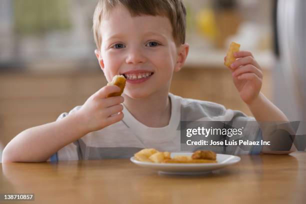 caucasian boy eating chicken nuggets - eating nuggets ストックフォトと画像