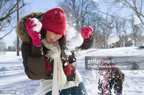 hispanic girls having snowball fight - snowball stock pictures, royalty-free photos & images