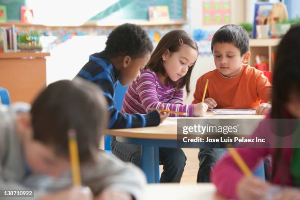 students studying in classroom - kids interacting in the classroom stock-fotos und bilder