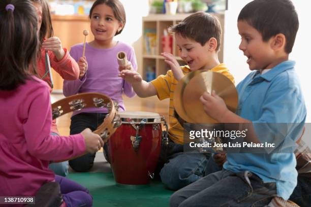 students playing musical instruments in classroom - percussion instrument stock pictures, royalty-free photos & images
